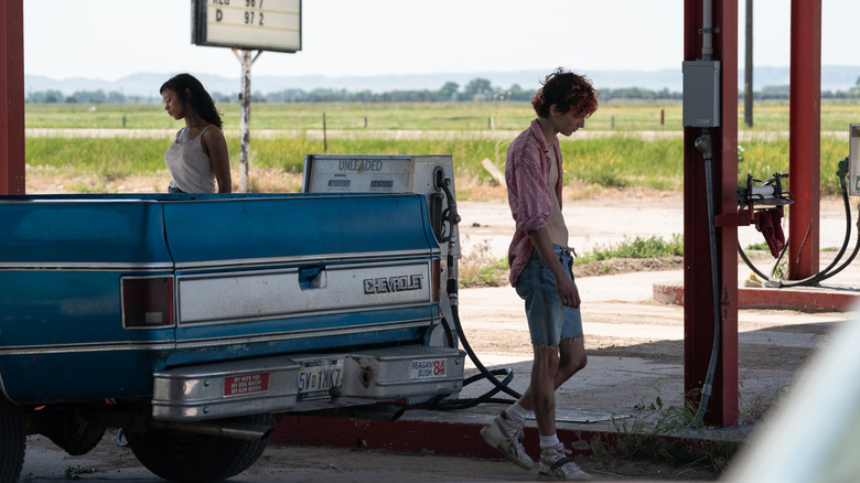 Taylor Russell and Timothée Chalamet stand outside gas station in Bones & All