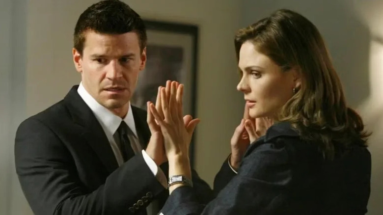 Emily Deschanel's Temperance Brennan and David Boreanaz's Seeley Booth pressing their hands together on Bones