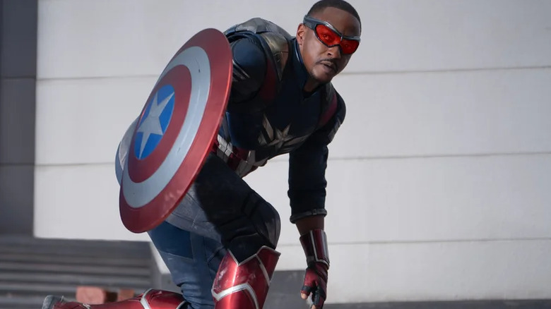 Sam Wilson berjongkok dan memegang Captain America Shield di Captain America: Brave New World