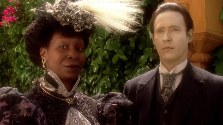 Guinean and data, in the nineteenth century clothes, stand in a garden. From Star Trek: The next generation.