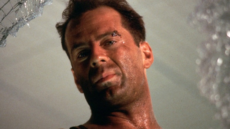 John McClane looking through a shattered window in Die Hard