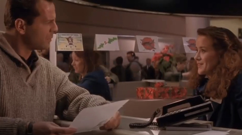 Bruce Willis' John McClane talks to a woman behind a counter at an airport in Die Hard 2