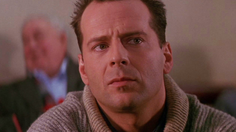 Bruce Willis' John McClane sits in an airport looking up and to the right in Die Hard 2