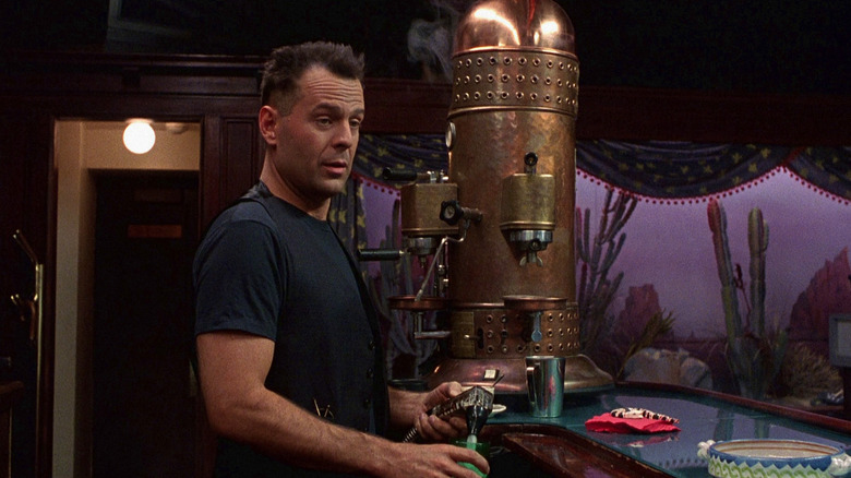 Hudson Hawk next to a huge cappuccino machine, located in a weird wild-west bar.