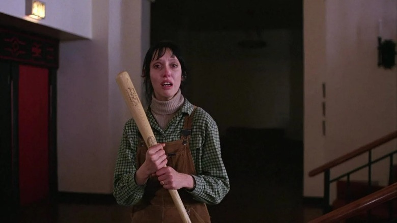 Wendy Torrance holding a baseball bat with reddish eyes in The Shining