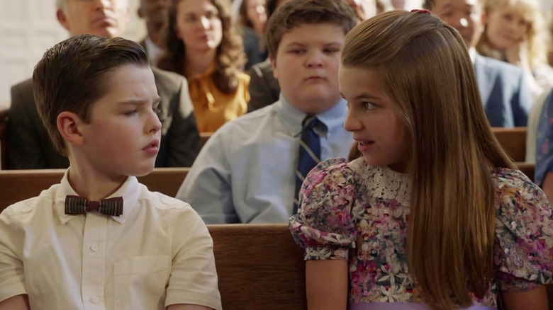 Iain Armitage as Sheldon and Raegan Revord as Missy sitting together in church in Young Sheldon