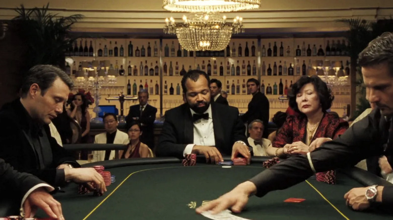 Le Chiffre Mads Mikkelsen, Felix Leiter Jeffrey Wright and Madame Tai Chin, sit at the table at the Royale Casino