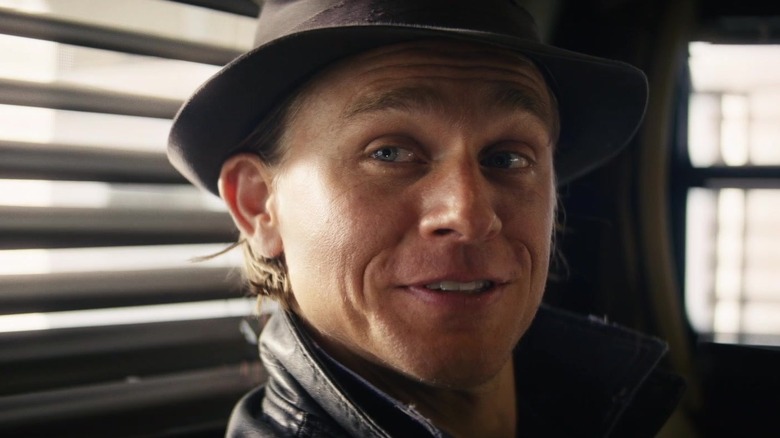 Charlie Hunnam como Charlie Waldo, sonriendo con un sombrero en Last Looks