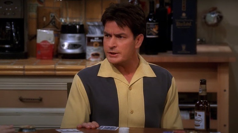 Charlie Harper sitting at a table on Two and a Half Men