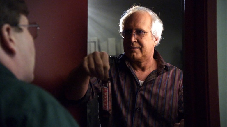 Chevy Chase as Pierce Hawthorne holding a candy bar in Community