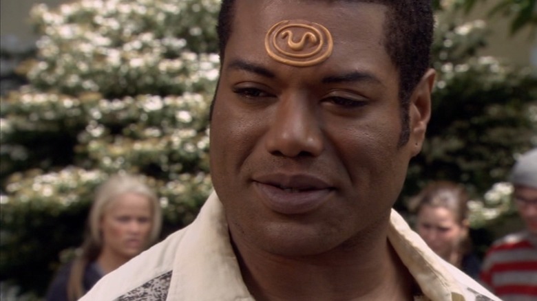 Teal'c de Christopher Judge sorrindo para si mesmo no Stargate SG-1