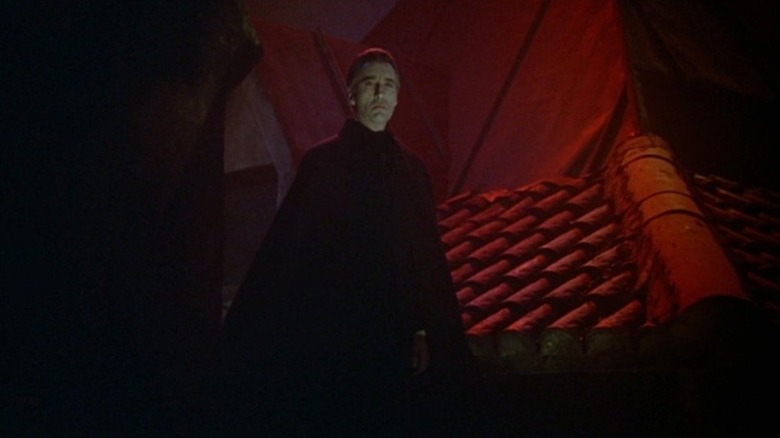 Christopher Lee as Dracula hanging on a rooftop in Dracula Has Risen from the Grave