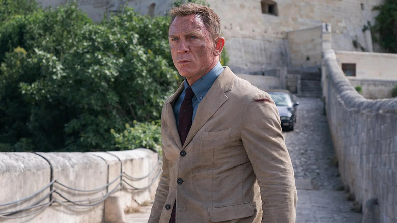 Daniel Craig's James Bond in his tan suit, dirty on the bridge in the cold open of No Time to Die