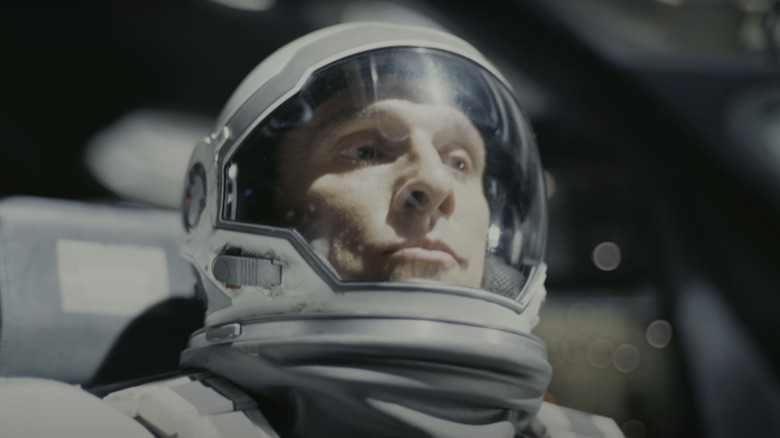 Matthew McConaughey's Joseph Cooper sits in a space suit in his shuttle as bright light hits his face in Interstellar