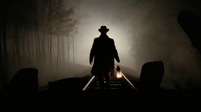 A figure walking on railroad tracks in The Assassination of Jesse James by the Coward Robert Ford