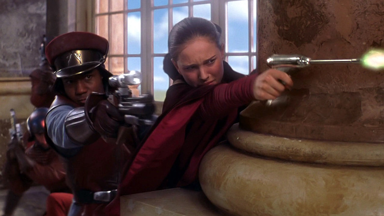 Hugh Quarshie and Natalie Portman as Quarsh Panaka and Amidala shooting blasters in Star Wars: The Phantom Menace