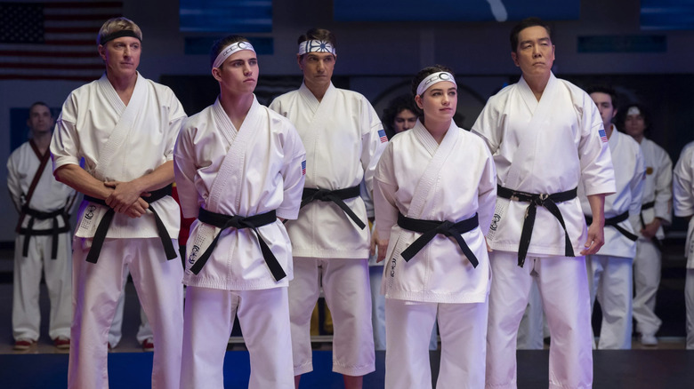 Johnny, Robbie, Daniel, Samantha, and Chozen standing together in Cobra Kai