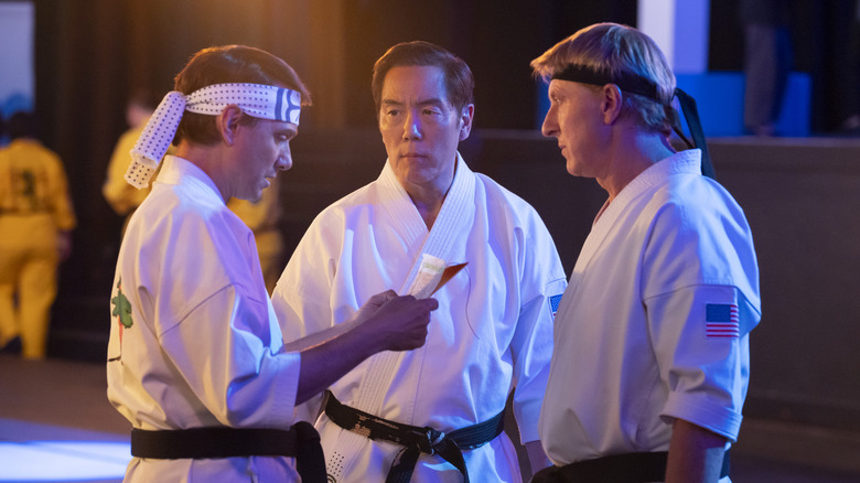 Daniel LaRusso, Johnny Lawrence, and Chozen Toguchi conferring at the Sekai Taikai in Cobra Kai