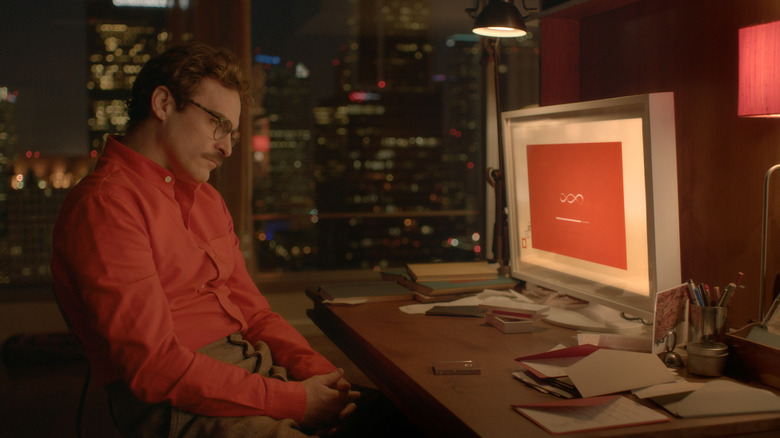 Joaquin Phoenix as Theodore sitting at his computer waiting for his new OS to boot up in Her (2013)