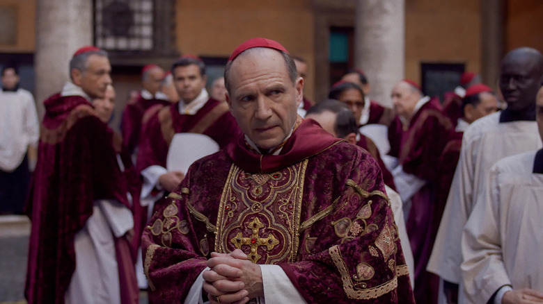 Lawrence in the courtyard looking suspicious in Conclave