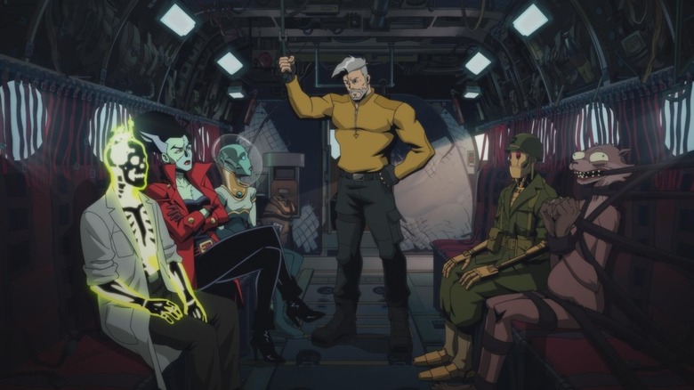 Task Force M sitting in an aircraft, while Weasel is chained to his seat in Creature Commandos