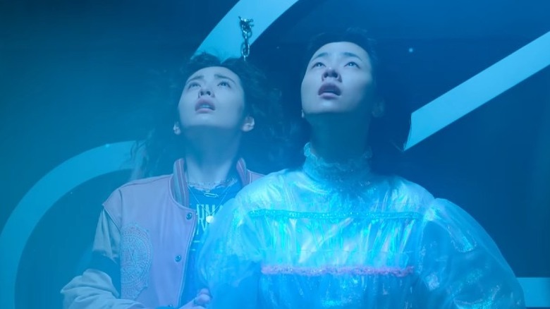 Two Korean women stare up at spacecraft