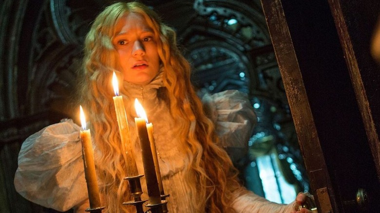 Mia Wasikowska holds a candelabra in Crimson Peak