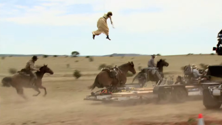 Olivia Wilde in the air above a fake horse