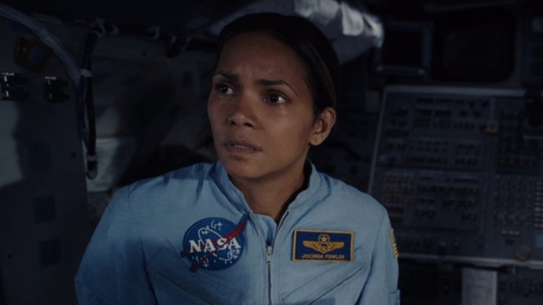 Halle Berry looking concerned in blue NASA spacesuit