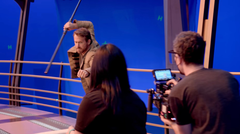 Ryan Reynolds performing martial arts on a blue screen set