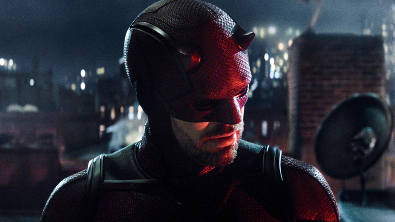 Charlie Cox sebagai Matt Murdock berdiri di atap, mendengarkan, di Daredevil: Born Again