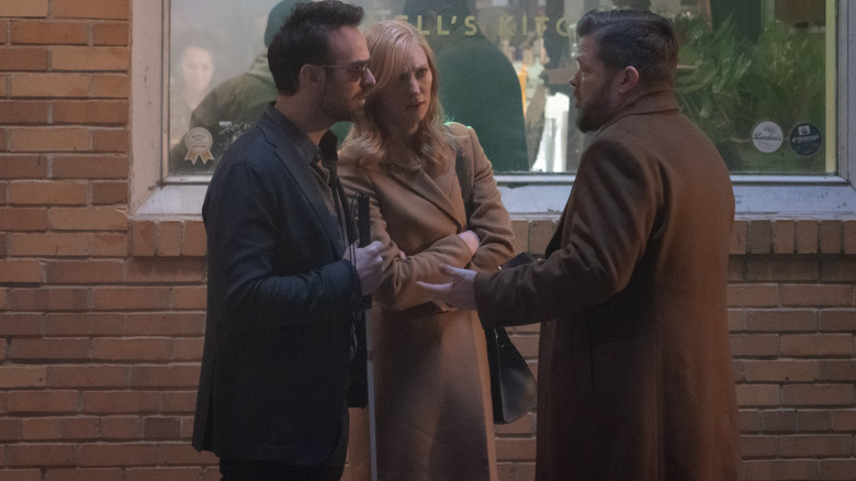 Charlie Cox as Matt Murdock, Deborah Ann Woll as Karen Page, and Elden Henson as Foggy Nelson talking outside of a bar in Daredevil: Born Again