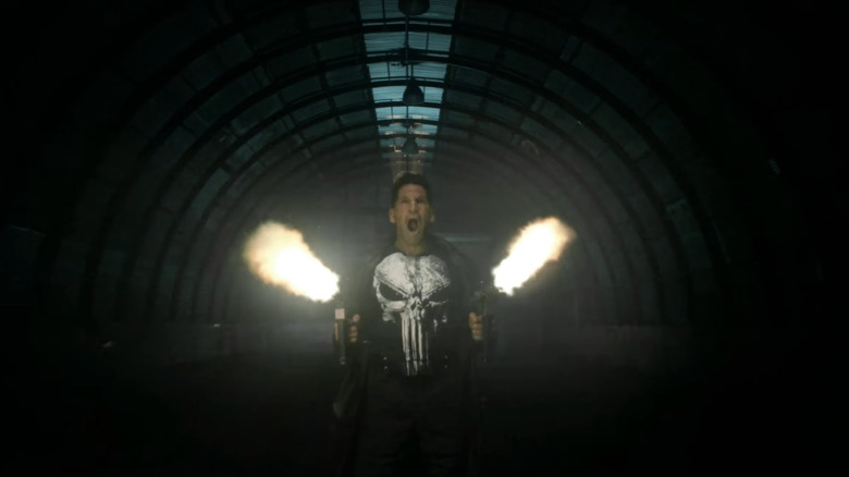 Jon Bernthal's Frank Castle stands in a tunnel shooting two guns in The Punisher