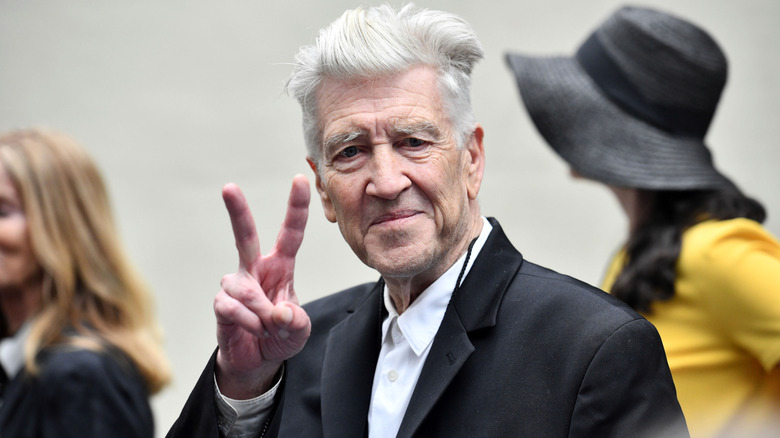 Director David Lynch raising two fingers in a peace sign