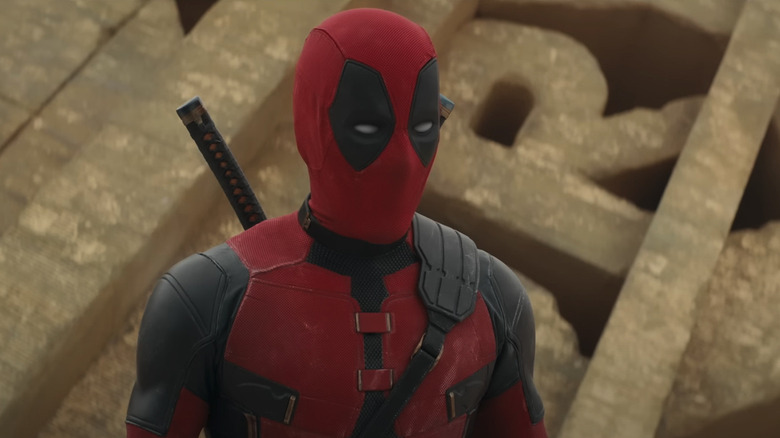 Deadpool standing in front of crumbled Fox logo in Deadpool and Wolverine