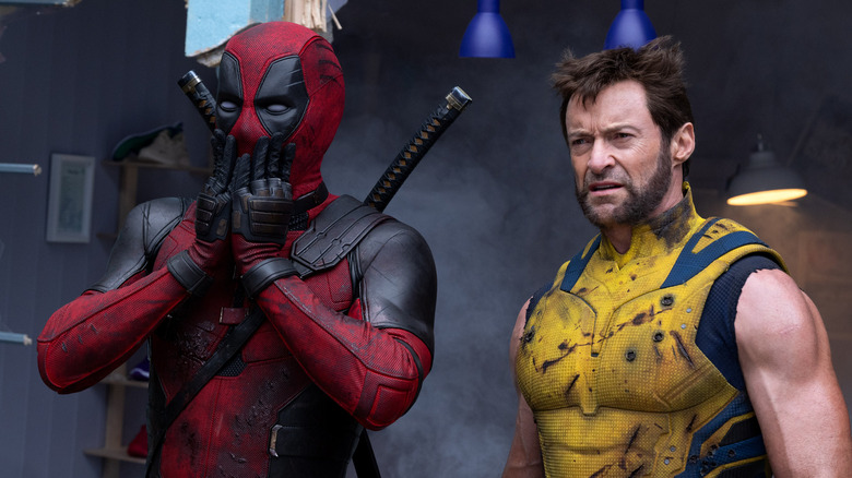 Deadpool covering his mouth in amazement while Wolverine looks unimpressed in Deadpool & Wolverine