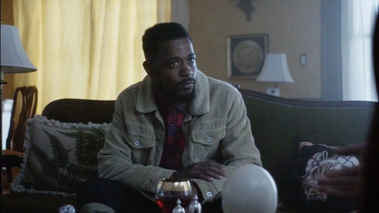 Lakeith sits on couch