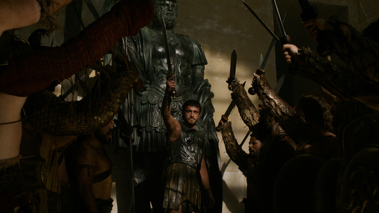 Paul Mescal as Lucius surrounded by soldiers with swords drawn in Gladiator 2