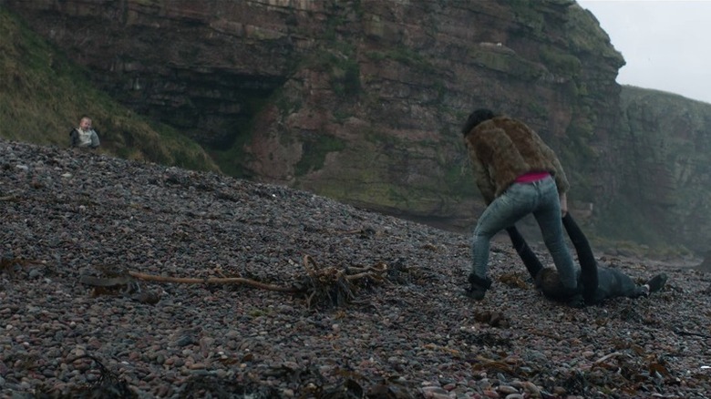 The Female drags body through beach as baby watches