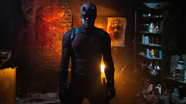 Charlie Cox as Daredevil in costume standing in Muse's lair in Daredevil: Born Again