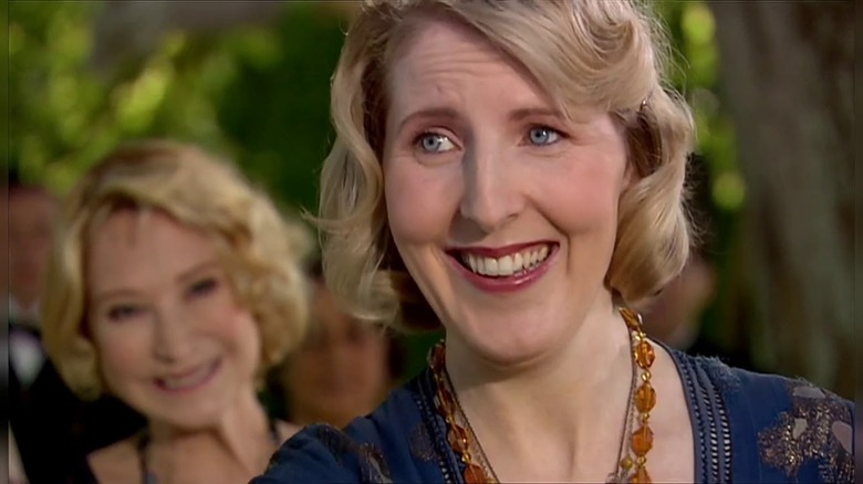 Agatha Christie (Fenella Woolgar) smiles at someone offscreen in an episode of Doctor Who