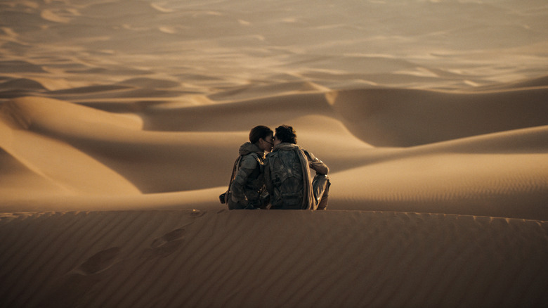 Paul and Chani kissing on top of a dune on Arrakis in Dune: Part Two