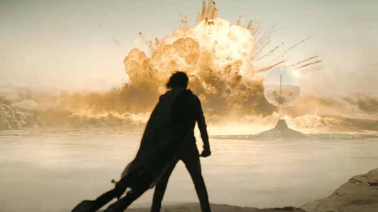 Paul looking at a faraway explosion in Dune: Part Two