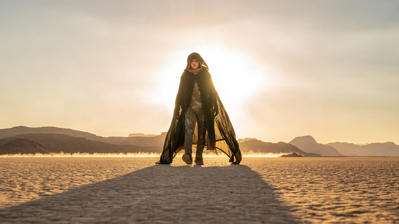 Paul Atreides walking through the desert on Arrakis in a hood and cape