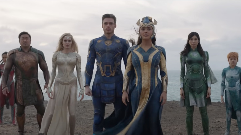six superheros in costume on a cliff against the ocean