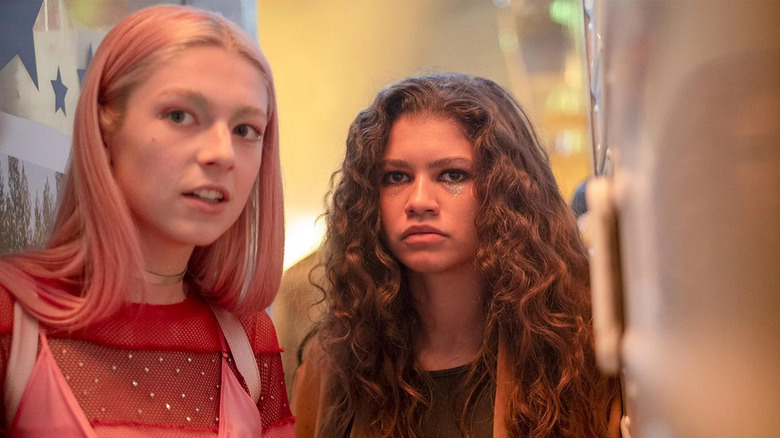 blonde and pink haired woman looking off camera and brunette woman looking in the same direction