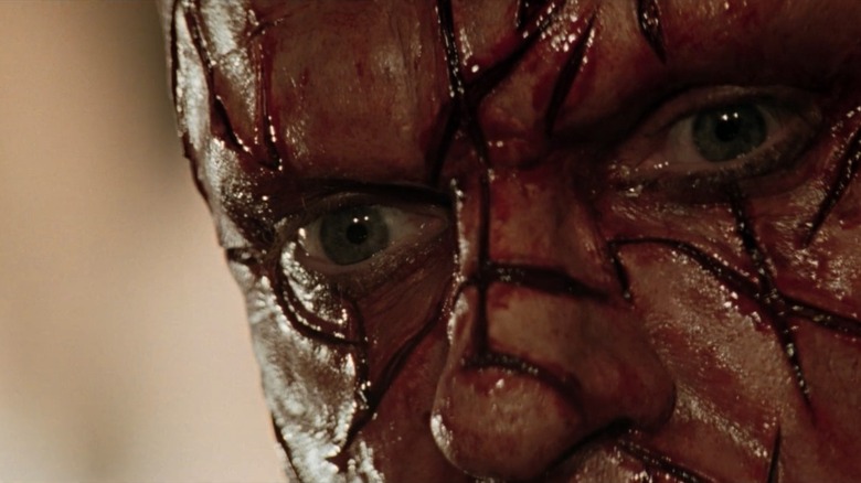 Closeup of Sam Neill as Weir, face sliced up in Event Horizon