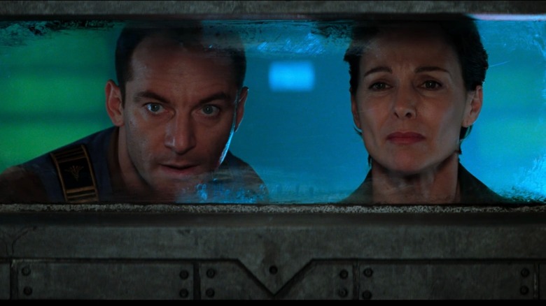 Jason Isaacs as DJ and Kathleen Quinlan as Peters looking through a window in Event Horizon