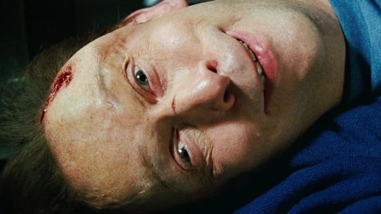 Tim Blake Nelson's Samuel Sterns lying on the floor and smiling