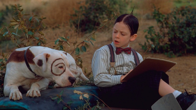 Alfalfa, writing something on a paper, talking to a dog in The Little Rascals